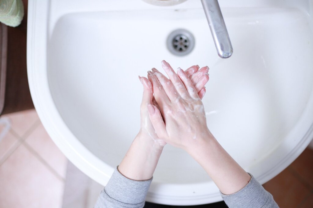 weekly sink maintenance routine with brush and hot water
