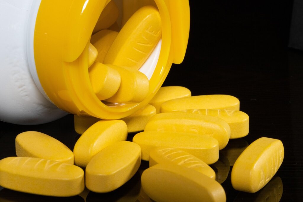 garlic cloves and vitamin B1 supplement capsules on a table
