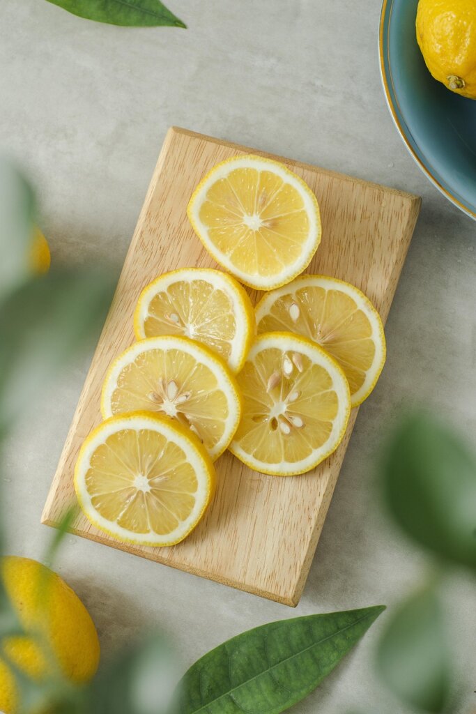 lemon halves with whole cloves inserted on wooden cutting board