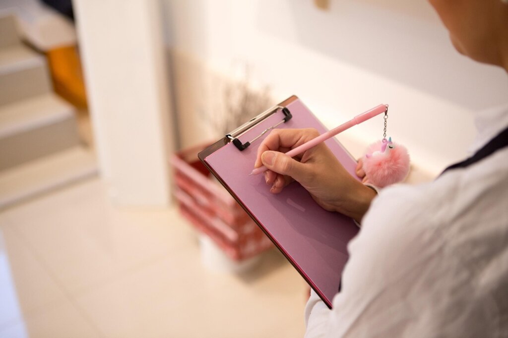 checklist on clipboard with house model and pen