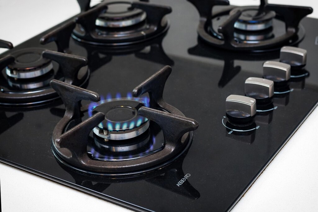 spray bottle of kitchen degreaser being applied to gas stove