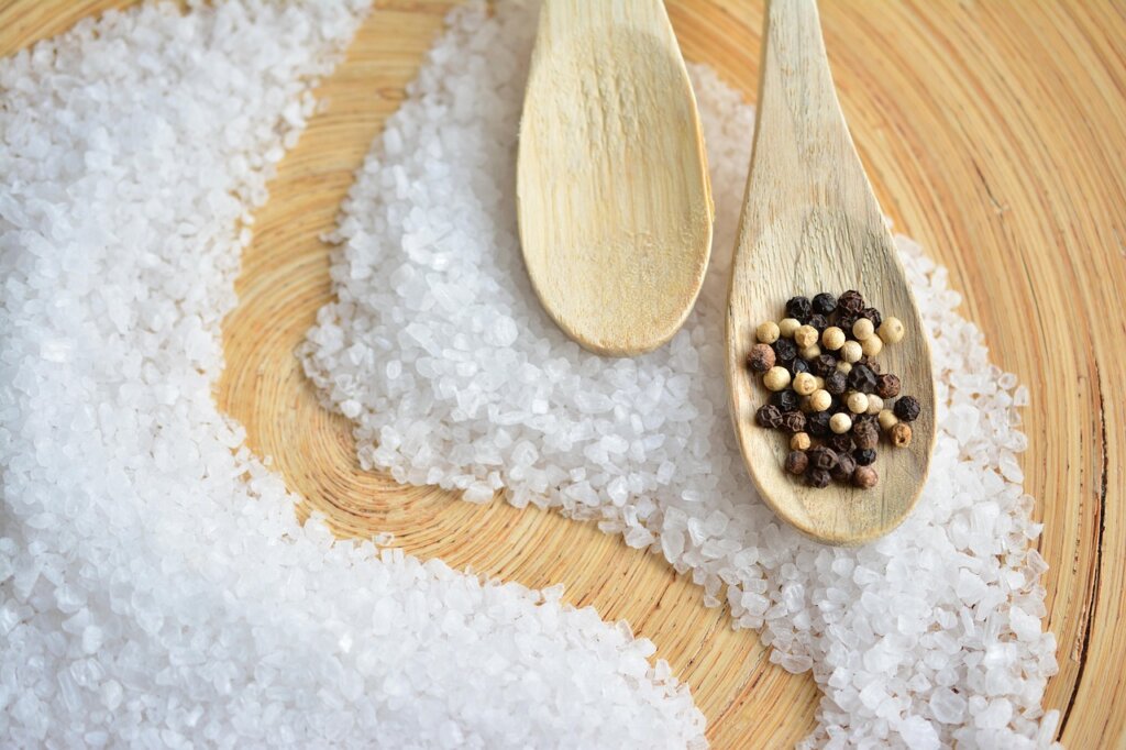 coarse salt being rubbed on wooden cutting board