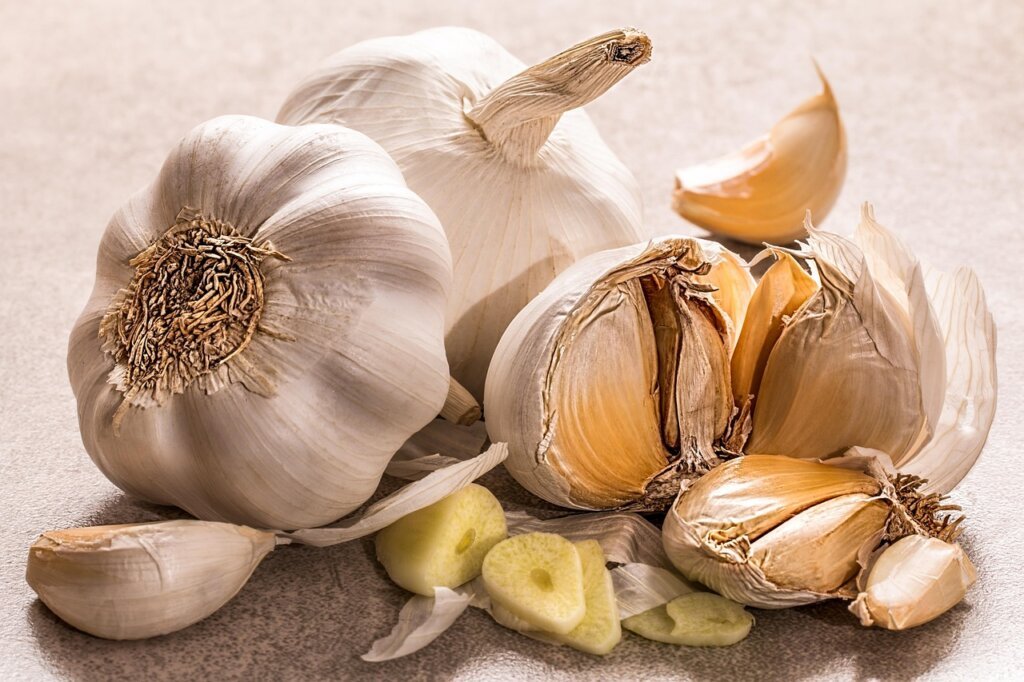 organized kitchen shelf with properly stored garlic in containers and baskets