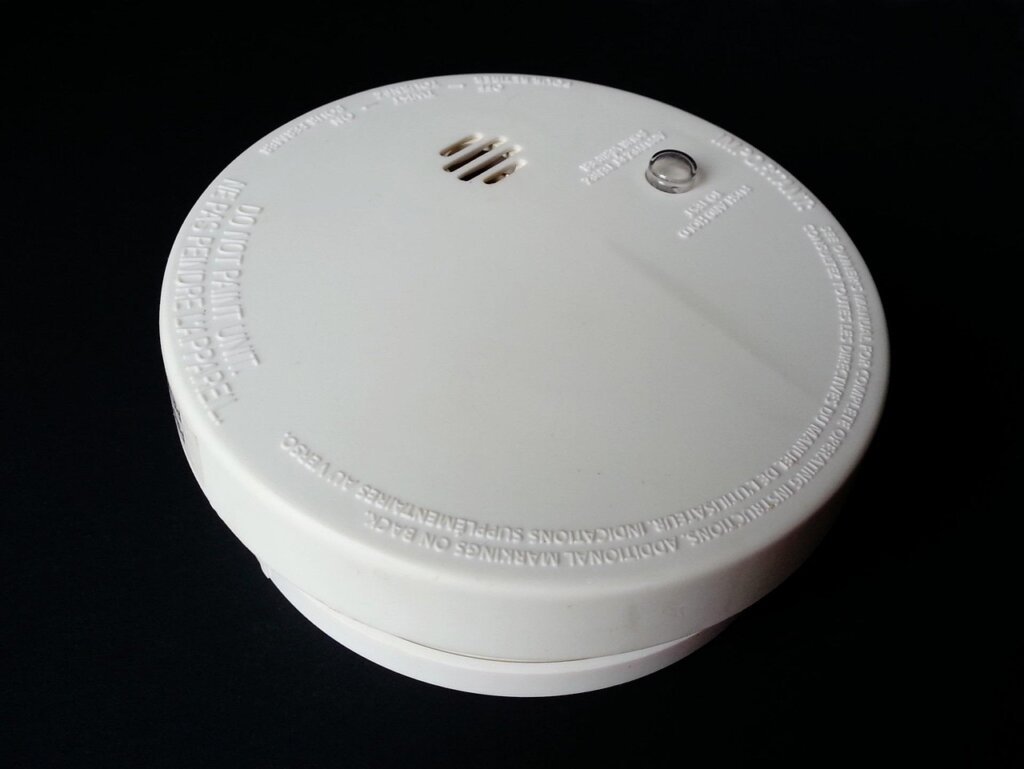 new smoke detector mounted on clean white ceiling