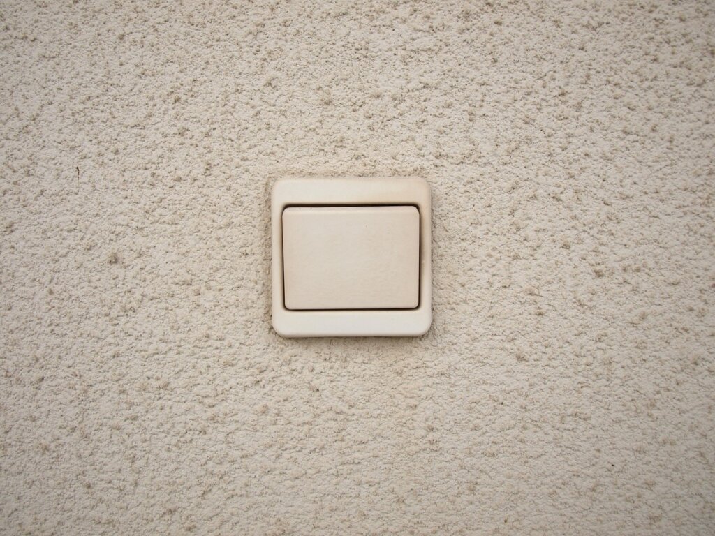 microfiber cloth cleaning greasy kitchen wall near light switch