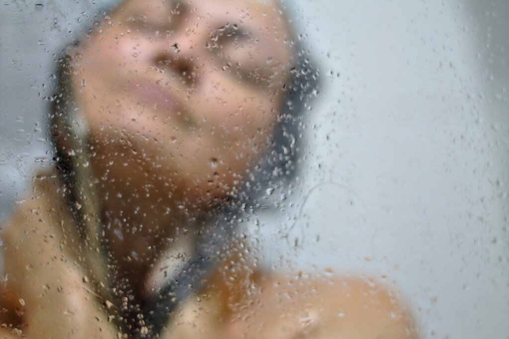 dirty glass shower door with hard water stains