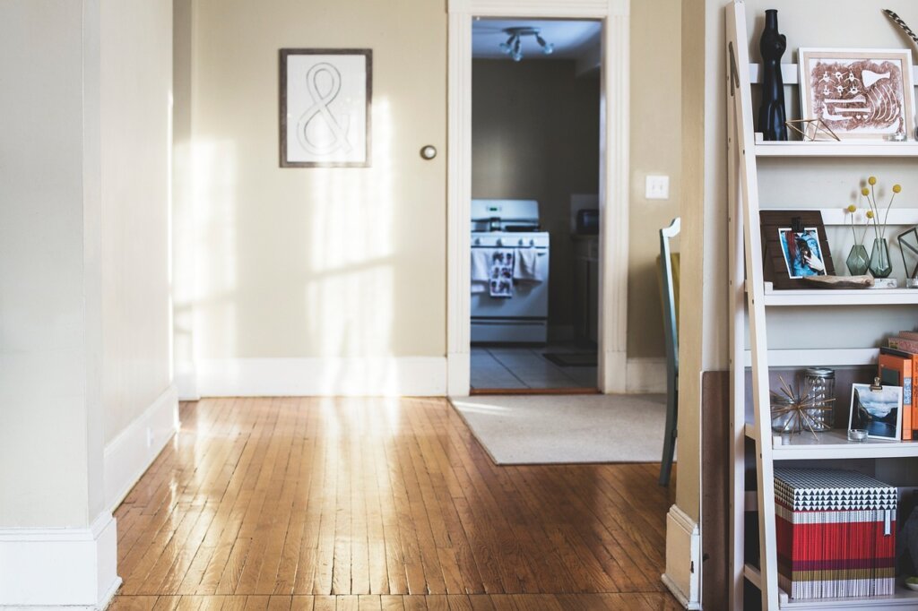 person placing newspaper on shoe cabinet shelf in a tidy entryway