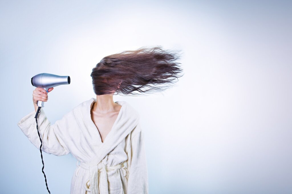 hair dryer set to cool air mode near open freezer